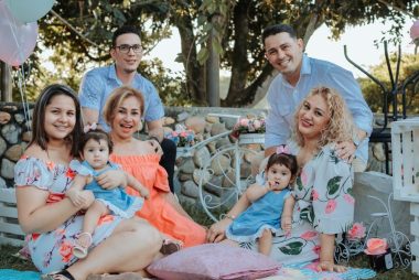 A joyful family enjoying an outdoor gathering in La Dorada, Colombia, surrounded by colorful decor.